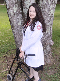 Kristal con su bata blanca que representa su calidad de enfermera registrada.